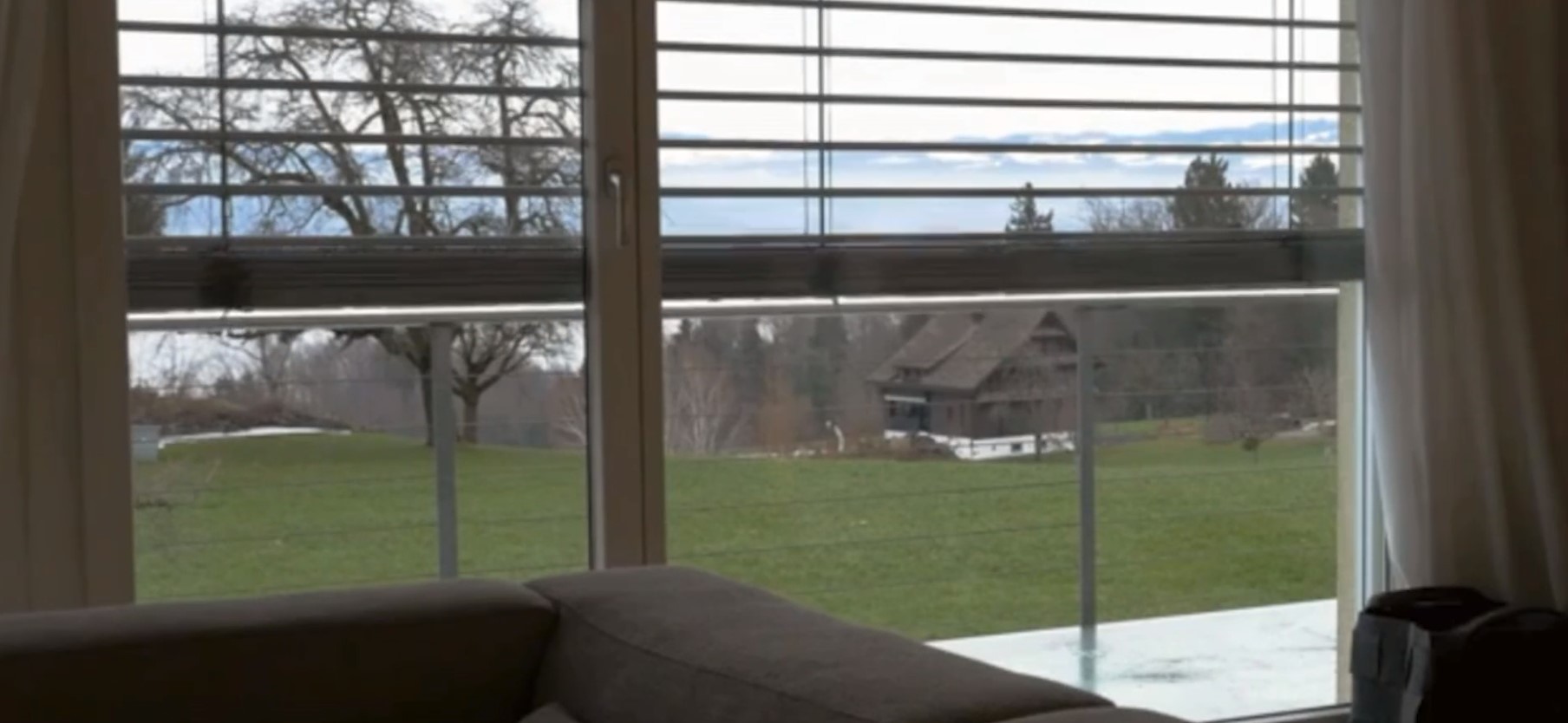 blinds motorization on a window looking out to green pasture
